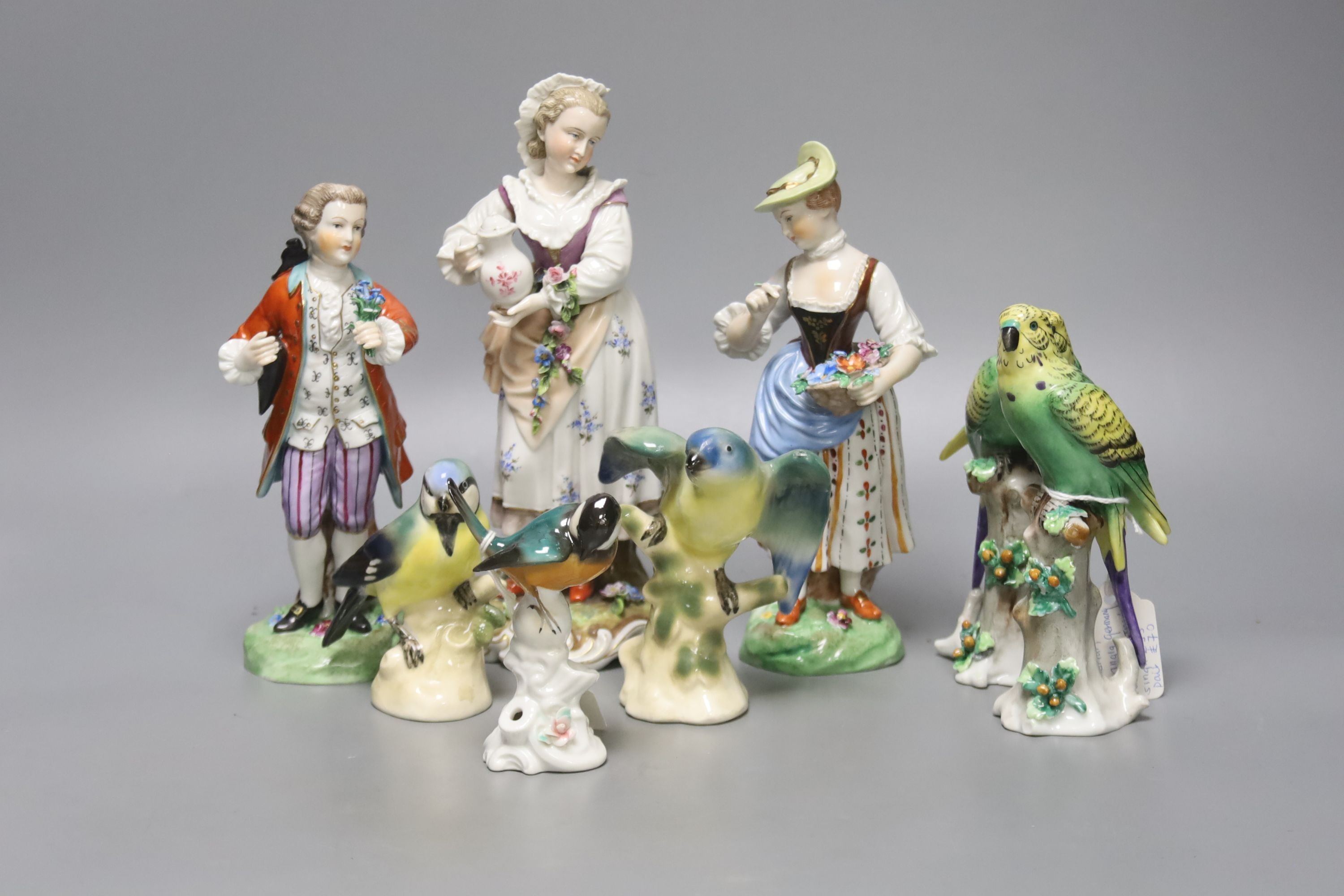 Three Continental figures and a collection of bird ornaments, tallest 22cm